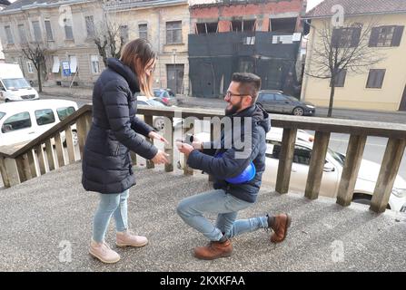 Dekan Jadanic machte seiner Freundin Ana Krznarevic am 9. Januar 2021 in den Ruinen einen Heiratsantrag vor dem Gesundheitszentrum in Petrinja, Kroatien. Sie trafen sich vor vier Jahren im Laden, wo sie arbeitete, an ihrem Geburtstag. Sie haben ein paar Monate später eine Beziehung begonnen und sind seitdem unzertrennlich. Dean arbeitet seit dreizehn Jahren als Medizintechniker am Petrinja Health Center, und nach dem letzten Erdbeben am 29. Dezember zog er sich kaum den Kopf raus. Jetzt helfen beide freiwillig den Opfern des Erdbebens, so dass sie selten einen sehen Stockfoto