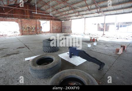 Weder die epidemiologischen Maßnahmen noch die Schließung der Fitnessstudios hindern viele Sportler am Sport. In einem der verlassenen Hangars der ehemaligen Kaserne von Luscic gibt es einen improvisierten Outdoor-Gym, der von jedem genutzt werden kann, der trainieren möchte. Trainingsgeräte bestehen aus alten Reifen, Ziegeln, ein wenig Beton, und alles, was man für ein gutes Training braucht, ist das Testament. In Karlovac, Kroatien, am 11. Januar 2021. Foto: Kristina Stedul Fabac/PIXSELL Stockfoto