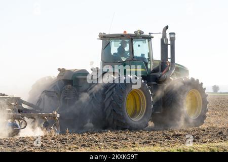Skagit Valley, WA, USA - 11. Oktober 2022; John Deere 9530 knickgelenkter 4WD-Traktor, der im Herbst auf einem trockenen und staubigen Feld eingesetzt wird Stockfoto