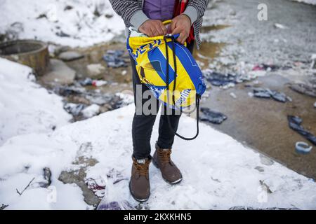 Ein Migrant aus Pakistan, Hagiaz Abdulrehman, reinigt sich am 15. Januar 2021 in einem Bach im Migrantenlager Lipa in der Nähe von Bihac, Bosnien und Herzegowina. Das Wasser in den Tanks ist heute Morgen gefroren, weil die Temperatur um 9 Uhr -14 Grad Celsius betrug. Camp Lipa wird in 3 Monaten voll funktionsfähig sein. Foto: Armin Durgut/PIXSELL Stockfoto