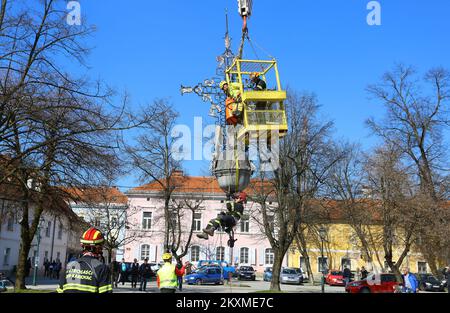 Entfernung von vergoldetem Querbarometer und Äpfeln aus der Kirche der Heiligen Dreifaltigkeit in Karlovac, Kroatien, am 2. März 2021. Aufgrund der Schäden nach dem Erdbeben wurden das Querbarometer und ein Apfel mit einem Gewicht von etwa 400 Kilogramm vom Glockenturm der ältesten Kirche in Karlovac entfernt. Die Krise ist 230 Jahre alt, und Feuerwehrleute haben sich mit Hilfe eines 60-Tonnen-Krans an der Überwindung der Krise beteiligt. Nur einige österreichisch-ungarische Städte hatten ein Kreuzbarometer, und Karlovac war bis heute unter ihnen. Foto: Kristina Stedul Fabac/PIXSELL Stockfoto