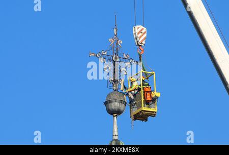 Entfernung von vergoldetem Querbarometer und Äpfeln aus der Kirche der Heiligen Dreifaltigkeit in Karlovac, Kroatien, am 2. März 2021. Aufgrund der Schäden nach dem Erdbeben wurden das Querbarometer und ein Apfel mit einem Gewicht von etwa 400 Kilogramm vom Glockenturm der ältesten Kirche in Karlovac entfernt. Die Krise ist 230 Jahre alt, und Feuerwehrleute haben sich mit Hilfe eines 60-Tonnen-Krans an der Überwindung der Krise beteiligt. Nur einige österreichisch-ungarische Städte hatten ein Kreuzbarometer, und Karlovac war bis heute unter ihnen. Foto: Kristina Stedul Fabac/PIXSELL Stockfoto