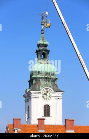 Entfernung von vergoldetem Querbarometer und Äpfeln aus der Kirche der Heiligen Dreifaltigkeit in Karlovac, Kroatien, am 2. März 2021. Aufgrund der Schäden nach dem Erdbeben wurden das Querbarometer und ein Apfel mit einem Gewicht von etwa 400 Kilogramm vom Glockenturm der ältesten Kirche in Karlovac entfernt. Die Krise ist 230 Jahre alt, und Feuerwehrleute haben sich mit Hilfe eines 60-Tonnen-Krans an der Überwindung der Krise beteiligt. Nur einige österreichisch-ungarische Städte hatten ein Kreuzbarometer, und Karlovac war bis heute unter ihnen. Foto: Kristina Stedul Fabac/PIXSELL Stockfoto