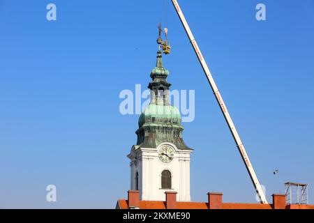 Entfernung von vergoldetem Querbarometer und Äpfeln aus der Kirche der Heiligen Dreifaltigkeit in Karlovac, Kroatien, am 2. März 2021. Aufgrund der Schäden nach dem Erdbeben wurden das Querbarometer und ein Apfel mit einem Gewicht von etwa 400 Kilogramm vom Glockenturm der ältesten Kirche in Karlovac entfernt. Die Krise ist 230 Jahre alt, und Feuerwehrleute haben sich mit Hilfe eines 60-Tonnen-Krans an der Überwindung der Krise beteiligt. Nur einige österreichisch-ungarische Städte hatten ein Kreuzbarometer, und Karlovac war bis heute unter ihnen. Foto: Kristina Stedul Fabac/PIXSELL Stockfoto