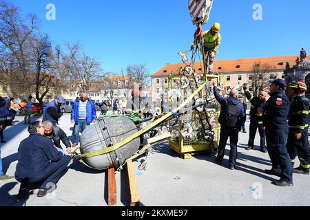 Entfernung von vergoldetem Querbarometer und Äpfeln aus der Kirche der Heiligen Dreifaltigkeit in Karlovac, Kroatien, am 2. März 2021. Aufgrund der Schäden nach dem Erdbeben wurden das Querbarometer und ein Apfel mit einem Gewicht von etwa 400 Kilogramm vom Glockenturm der ältesten Kirche in Karlovac entfernt. Die Krise ist 230 Jahre alt, und Feuerwehrleute haben sich mit Hilfe eines 60-Tonnen-Krans an der Überwindung der Krise beteiligt. Nur einige österreichisch-ungarische Städte hatten ein Kreuzbarometer, und Karlovac war bis heute unter ihnen. Foto: Kristina Stedul Fabac/PIXSELL Stockfoto