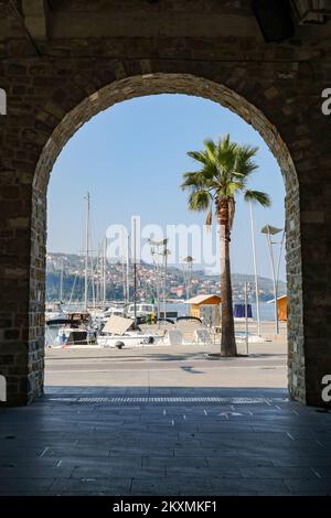 Koper, Slowenien - 14. Oktober 2022: Silhouetten der Arkaden von Taverna in der Stadt Koper mit Blick auf den Hafen. Stockfoto