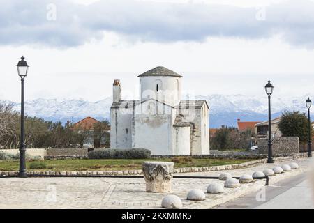 Die Bilder zeigen den Fuß des Denkmals für St. Gregory von Nin mit Blick auf die Kirche des Heiligen Kreuzes, die als kleinste Kathedrale der Welt bezeichnet wird, ist das wertvollste erhaltene Denkmal der alten kroatischen Kirchenarchitektur und eines der Symbole von Nin., in Nin, Kroatien, am 15. März 2021. Foto: Marko Dimic/PIXSELL Stockfoto