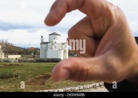 Die Bilder zeigen den Fuß des Denkmals für St. Gregory von Nin mit Blick auf die Kirche des Heiligen Kreuzes, die als kleinste Kathedrale der Welt bezeichnet wird, ist das wertvollste erhaltene Denkmal der alten kroatischen Kirchenarchitektur und eines der Symbole von Nin., in Nin, Kroatien, am 15. März 2021. Foto: Marko Dimic/PIXSELL Stockfoto