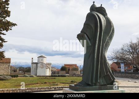 Die Bilder zeigen den Fuß des Denkmals für St. Gregory von Nin mit Blick auf die Kirche des Heiligen Kreuzes, die als kleinste Kathedrale der Welt bezeichnet wird, ist das wertvollste erhaltene Denkmal der alten kroatischen Kirchenarchitektur und eines der Symbole von Nin., in Nin, Kroatien, am 15. März 2021. Foto: Marko Dimic/PIXSELL Stockfoto