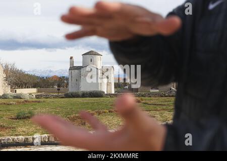 Die Bilder zeigen den Fuß des Denkmals für St. Gregory von Nin mit Blick auf die Kirche des Heiligen Kreuzes, die als kleinste Kathedrale der Welt bezeichnet wird, ist das wertvollste erhaltene Denkmal der alten kroatischen Kirchenarchitektur und eines der Symbole von Nin., in Nin, Kroatien, am 15. März 2021. Foto: Marko Dimic/PIXSELL Stockfoto