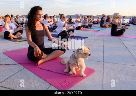 Die Menschen üben Yoga, während die Sonne untergeht am Gruß zur Sonne Monument im Rahmen der Feier des Inernational Yoga Day in Zadar, Kroatien am 17. Juni 2021. Das Denkmal wurde vom kroatischen Architekten Nikola Basic entworfen und symbolisiert die Kommunikation mit der Natur und kommuniziert mit Licht. Foto: Dino Stanin/PIXSELL Stockfoto