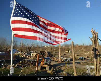 Tornado - Henryville, Ind , 8. März 2012 die amerikanische Flagge weht als Symbol der Hoffnung über die zerstörten Häuser und gestreiften Hügel, nachdem zwei Tornados die Gemeinde von 1.900 Einwohnern im Süden Indianas am 2. März durchbrachen. Präsident Obama gab am 9. März, zwei Tage nach Abschluss der Gemeinsamen vorläufigen Schadensbewertungen in sechs Bezirken, eine Erklärung über eine Katastrophe größeren Ausmaßes ab. Indiana schwere Stürme, Stürme und Tornados. Fotos zu Katastrophen- und Notfallmanagementprogrammen, Aktivitäten und Beamten Stockfoto