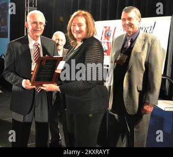 Orlando, Florida , 27. März 2012 Mary Hudak, Direktorin der Region IV für Auswärtige Angelegenheiten der FEMA, wird mit dem Preis für ausgezeichneten Service des ehemaligen Direktors des National Hurricane Center Max Mayfield (links) ausgezeichnet. Und derzeitiger Direktor des National Hurricane Center Bill Reed (rechts) bei der National Hurricane Conference 2012 in Orlando, Florida. FEMA-Foto... Fotos zu Katastrophen- und Notfallmanagementprogrammen, Aktivitäten und Beamten Stockfoto