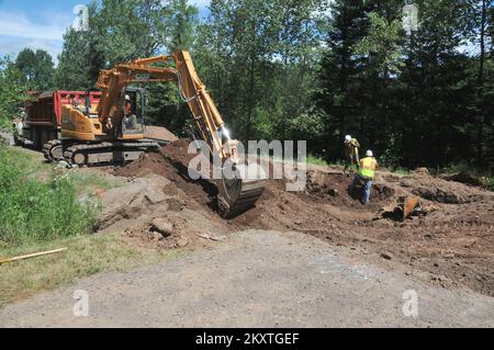 Überschwemmung Bei Schwerem Sturm - Duluth, Minnesota , 23. Juli 2012 Bauunternehmer reparieren einen Kanal und eine Straßenwäsche entlang der St. Louis County Road 36, verursacht durch die starken Stürme und Überschwemmungen von June in Minnesota. Die FEMA wird bis zu 75 Prozent der förderfähigen Kosten für die Reparatur der durch die Überschwemmungen beschädigten öffentlichen Infrastruktur übernehmen. Norman Lenburg/FEMA. Schwere Stürme Und Überschwemmungen In Minnesota. Fotos zu Katastrophen- und Notfallmanagementprogrammen, Aktivitäten und Beamten Stockfoto