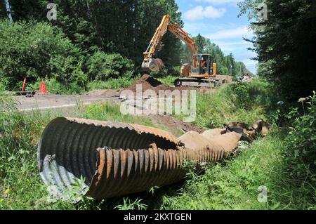 Überschwemmung Bei Schwerem Sturm - Duluth, Minnesota , 23. Juli 2012 Bauunternehmer reparieren einen Kanal und eine Straßenwäsche entlang der St. Louis County Road 36, verursacht durch die starken Stürme und Überschwemmungen von June in Minnesota. Die FEMA wird bis zu 75 Prozent der förderfähigen Kosten für die Reparatur der durch die Überschwemmungen beschädigten öffentlichen Infrastruktur übernehmen. Norman Lenburg/FEMA. Schwere Stürme Und Überschwemmungen In Minnesota. Fotos zu Katastrophen- und Notfallmanagementprogrammen, Aktivitäten und Beamten Stockfoto