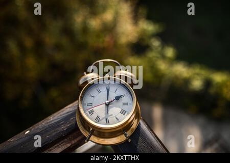 Illustration zum Thema Zeitänderung, Wecker in Herbstblättern. Jedes Jahr im Herbst wird die Zeit um eine Stunde von 3:00 Uhr auf 2:00 Uhr verschoben. In diesem Jahr fällt die Zeitumstellung auf die Winterzeit auf den 31. Oktober. Foto: Igor Soban/PIXSELL Stockfoto