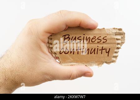 Wirtschaft und Finanzen. Ein Mann hält ein Pappkarton in der Hand, auf dem es steht: Business Continuity Stockfoto