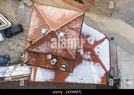 Ein von einer Drohne aufgenommenes Bild zeigt Inat House (Trotzhaus). Als der Standort für den Bau des Rathauses in Sarajewo ermittelt wurde, entschieden die österreichisch-ungarischen Behörden, dass der Bau den Abriss von zwei Restaurants und einem Haus erforderte. Der Besitzer des Hauses hat es aus irgendeinem Grund nicht abgerissen. Nach langen Verhandlungen bat er darum, in Dukaten bezahlt zu werden und sein Haus auf die andere Seite der Küste zu verlegen, Stein für Stein. Sie taten es und es heißt seitdem Inat House (Spite House). Heute beherbergt es ein berühmtes Restaurant in Sarajevo, Bosnien und H. Stockfoto