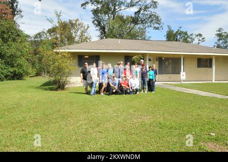 Slidell, La., 18. Oktober 2012 FEMA Future Leaders Participants posieren für ein Foto vor dem zweiten von Hurrikan Isaac überfluteten Haus, wo sie sich freiwillig die Zeit gaben, das Innere zu streichen... Louisiana Hurrikan Isaac. Fotos zu Katastrophen- und Notfallmanagementprogrammen, Aktivitäten und Beamten Stockfoto