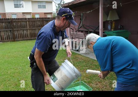 Slidell, La., 18. Oktober 2012 FEMA Future Leaders Teilnehmer Jeffery Lucas hilft, indem er Farbe in die Tabletts seiner Kollegen gießt, um das Haus der beiden Überlebenden zu streichen, die vom Hurrikan Isaac Flutwasser betroffen sind. Louisiana Hurrikan Isaac. Fotos zu Katastrophen- und Notfallmanagementprogrammen, Aktivitäten und Beamten Stockfoto