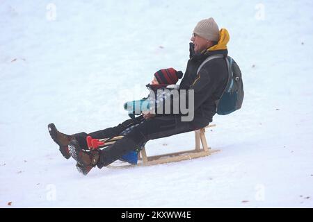 Vater und Kind genießen Schlittenfahrten auf Sljeme, dem Gipfel von Medvednica, in Zagreb, Kroatien, am 27. Dezember 2021. Foto: Matija Habljak/PIXSELL Stockfoto