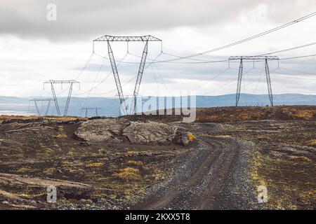 Hochspannungskabel an Masten, vor dem Hintergrund eines bewölkten Himmels Stockfoto