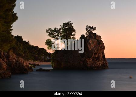 Sonnenuntergang über dem Brela Stone in Brela, Kroatien am 15. Januar 2022. Das Symbol von Brela ist „Kamen Brela“ (Brela Stone), eine kleine Felseninsel gleich neben dem Hauptstrand von Brela, dem Strand von Punta Rata. Im Jahr 2004 hat das amerikanische Magazin Forbes den Punta Rata Beach auf die Liste der 10 schönsten Strände der Welt gesetzt, wo er auf Platz 6. der Welt und auf Platz 1. in Europa steht. Foto: Matko Begovic/HaloPix/PIXSELL Stockfoto