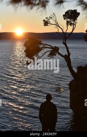 Sonnenuntergang über dem Brela Stone in Brela, Kroatien am 15. Januar 2022. Das Symbol von Brela ist „Kamen Brela“ (Brela Stone), eine kleine Felseninsel gleich neben dem Hauptstrand von Brela, dem Strand von Punta Rata. Im Jahr 2004 hat das amerikanische Magazin Forbes den Punta Rata Beach auf die Liste der 10 schönsten Strände der Welt gesetzt, wo er auf Platz 6. der Welt und auf Platz 1. in Europa steht. Foto: Matko Begovic/HaloPix/PIXSELL Stockfoto