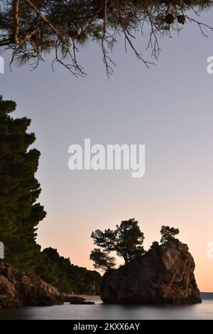 Sonnenuntergang über dem Brela Stone in Brela, Kroatien am 15. Januar 2022. Das Symbol von Brela ist „Kamen Brela“ (Brela Stone), eine kleine Felseninsel gleich neben dem Hauptstrand von Brela, dem Strand von Punta Rata. Im Jahr 2004 hat das amerikanische Magazin Forbes den Punta Rata Beach auf die Liste der 10 schönsten Strände der Welt gesetzt, wo er auf Platz 6. der Welt und auf Platz 1. in Europa steht. Foto: Matko Begovic/HaloPix/PIXSELL Stockfoto