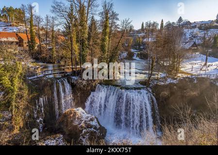 Die Bilder zeigen einen märchenhaften Blick auf Rastoke im Winter. Die malerische Kleinstadt Rastoke in Karlovac County ist eine der attraktivsten Touristenattraktionen in Kroatien, wo das Leben von zwei Flüssen diktiert wird: Slunjcica und Korana. In Rastoke wächst und fließt Slunjcica über Travertin-Felsen in den Fluss Korana, und in seinem Lauf entstehen viele Seen, Stromschnellen und Wasserfälle, von denen die berühmtesten Buk, Hrvoje und Vilina kosa sind. Sie werden oft Klein-Plitvicer genannt, weil die geologische Zusammensetzung der Wasserfälle die gleiche ist wie im Nationalpark Plitvicer Seen., in Rastoke, Kroatien Stockfoto