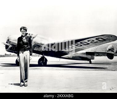 Amelia Earhart steht vor der Lockheed Electra, in der sie im Juli 1937 verschwand. Amelia Earhart wurde 1897 in Atchison, Kansas, geboren und begann erst nach ihrem Umzug nach Kalifornien 1920 zu fliegen. Nachdem Earhart in einer Curtiss Jenny Unterricht von der Flugpionierin Neta Snook genommen hatte, brach er die Flugrekorde ab und brach 1922 die Höhenrekorde der Frauen. Earhart förderte fortwährend Frauen in der Luftfahrt und wurde 1928 eingeladen, die ersten Frauen zu sein, die über den Atlantik flogen. Begleitende Piloten Wilmer Stultz und Louis Gordon als Passagier auf der Fokker Friendship, Earhart wurde ein Stockfoto