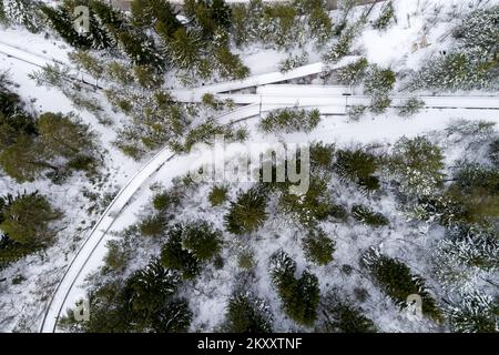 Luftfoto der Bobbahn auf dem Trebevic-Berg in Sarajevo, Bosnien und Herzegowina, am 9. Februar 2022. Als Sarajevo die Olympischen Winterspiele 1984 im Jahr 1977 erhielt, wurde ein Bobschlitten- und Rodelbahn vorgeschlagen. Die Konstruktion der Raupenketten wurde 1981 genehmigt, und der Bau begann am 1. Juni dieses Jahres. Die Montage der Kette wurde am 30. September 1982 abgeschlossen. Die Gleise wurden durch die Belagerung von Sarajewo vom 5. April 1992 bis zum 29. Februar 1996 während des bosnischen Krieges beschädigt. Während der Belagerung wurde die Strecke von bosnischen serbischen Streitkräften als Artillerieposition genutzt. Foto: Armin Durgut/PIXSELL Stockfoto