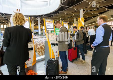 DÜSSELDORF, DEUTSCHLAND - 16. SEPTEMBER 2014: Passagiere nutzen Check-in-Automaten am Flughafen. Der Flughafen Düsseldorf ist der internationale Flughafen von Düsseldorf Stockfoto