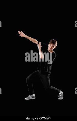 Junger Mann in schwarzem T-Shirt und Jeans tanzen Stockfoto