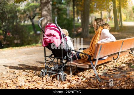 Großmutter mit Kinderwagen und Enkelin im Park. Platz für Text. Stockfoto