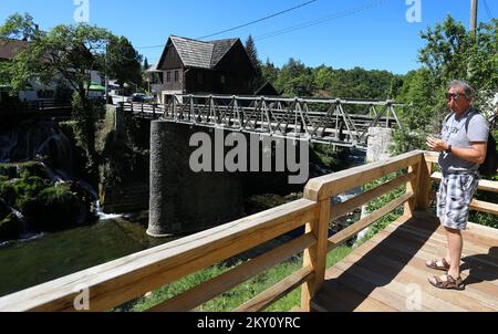 Touristen genießen den Fluss Slunjcica im Dorf Rastoke in der Nähe von Slunj, Kroatien, am 19. Mai 2022. In Rastoke teilt sich der Slunjcica River in mehrere Flusszweige, die über Kaskaden und kleine Wasserfälle in den Fluss Korana fließen. Foto: Kristina Stedul Fabac/PIXSELL Stockfoto