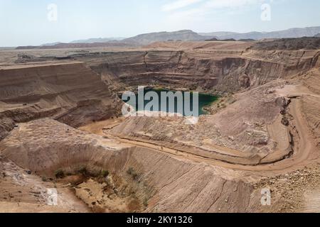 Tiefgrüner versteckter See in Timna, umgeben von Bergen. Stockfoto