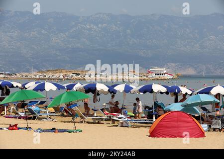 Der Sandstrand von Paradise (Rajska plaza) ist am 2. Juli 2022 in Lopar auf der Insel Rab, Kroatien, von Badenden überfüllt. Der größte und berühmteste Sandstrand in Lopar ist Rajska plaza (Paradise Beach). Es ist fast 2 km lang und bietet eine große Vielfalt an touristischen Einrichtungen. Es wurde mit der „Blauen Flagge“ für Wasserqualität, Umweltschutz und Sicherheit ausgezeichnet. Es hat es sogar auf CNN's Liste der Top 100 World Beaches geschafft. Foto: Goran Kovacic/PIXSELL Stockfoto