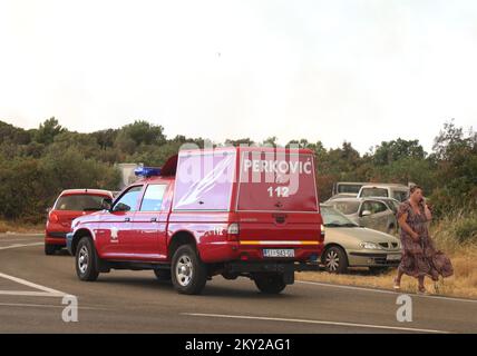 Die Leute parkten ihre Autos in der Nähe des Zaton-Geländes im Hinterland von Vodice, wo die Straße aufgrund eines großen Feuers gesperrt ist, Kroatien am 13. Juli 2022. Etwa 30 Feuerwehrleute mit einem Dutzend Fahrzeugen sind am Boden, und zwei Canadairs haben das Feuer gemeinsam mit den Bodentruppen gelöscht. Es gibt Kiefernwälder oben, niedrige Vegetation und gefährdete Gebäude. Foto: Dusko Jaramaz/PIXSELL Stockfoto