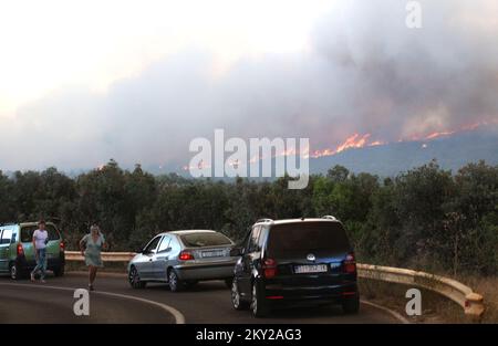 Die Leute parkten ihre Autos in der Nähe des Zaton-Geländes im Hinterland von Vodice, wo die Straße aufgrund eines großen Feuers gesperrt ist, Kroatien am 13. Juli 2022. Etwa 30 Feuerwehrleute mit einem Dutzend Fahrzeugen sind am Boden, und zwei Canadairs haben das Feuer gemeinsam mit den Bodentruppen gelöscht. Es gibt Kiefernwälder oben, niedrige Vegetation und gefährdete Gebäude. Foto: Dusko Jaramaz/PIXSELL Stockfoto