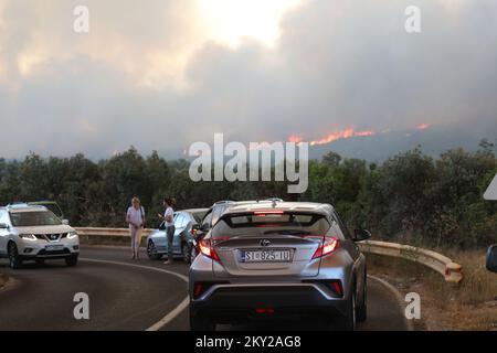 Die Leute parkten ihre Autos in der Nähe des Zaton-Geländes im Hinterland von Vodice, wo die Straße aufgrund eines großen Feuers gesperrt ist, Kroatien am 13. Juli 2022. Etwa 30 Feuerwehrleute mit einem Dutzend Fahrzeugen sind am Boden, und zwei Canadairs haben das Feuer gemeinsam mit den Bodentruppen gelöscht. Es gibt Kiefernwälder oben, niedrige Vegetation und gefährdete Gebäude. Foto: Dusko Jaramaz/PIXSELL Stockfoto