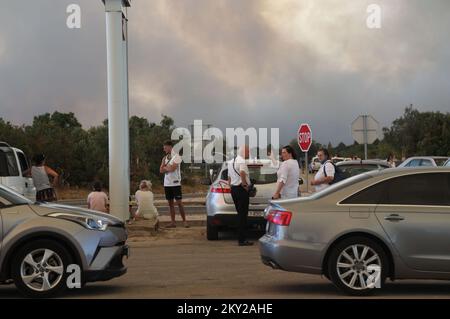 Die Leute parkten ihre Autos in der Nähe des Zaton-Geländes im Hinterland von Vodice, wo die Straße aufgrund eines großen Feuers gesperrt ist, Kroatien am 13. Juli 2022. Etwa 30 Feuerwehrleute mit einem Dutzend Fahrzeugen sind am Boden, und zwei Canadairs haben das Feuer gemeinsam mit den Bodentruppen gelöscht. Es gibt Kiefernwälder oben, niedrige Vegetation und gefährdete Gebäude. Foto: Dusko Jaramaz/PIXSELL Stockfoto