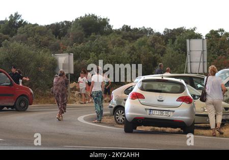 Die Leute parkten ihre Autos in der Nähe des Zaton-Geländes im Hinterland von Vodice, wo die Straße aufgrund eines großen Feuers gesperrt ist, Kroatien am 13. Juli 2022. Etwa 30 Feuerwehrleute mit einem Dutzend Fahrzeugen sind am Boden, und zwei Canadairs haben das Feuer gemeinsam mit den Bodentruppen gelöscht. Es gibt Kiefernwälder oben, niedrige Vegetation und gefährdete Gebäude. Foto: Dusko Jaramaz/PIXSELL Stockfoto