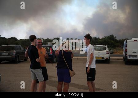 Die Leute parkten ihre Autos in der Nähe des Zaton-Geländes im Hinterland von Vodice, wo die Straße aufgrund eines großen Feuers gesperrt ist, Kroatien am 13. Juli 2022. Etwa 30 Feuerwehrleute mit einem Dutzend Fahrzeugen sind am Boden, und zwei Canadairs haben das Feuer gemeinsam mit den Bodentruppen gelöscht. Es gibt Kiefernwälder oben, niedrige Vegetation und gefährdete Gebäude. Foto: Dusko Jaramaz/PIXSELL Stockfoto