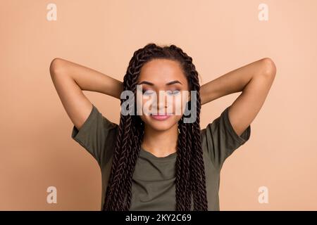 Foto von oben von einem jungen, gut gelaunten Mädchen Have Break Genießen Sie freies Wochenende isoliert auf beigefarbenem Hintergrund Stockfoto