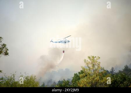 Feuerwehrleute versuchen mit einem Hubschrauber, ein Waldfeuer im Dorf Temnica in Slowenien, 22. Juli 2022 zu löschen. Rund 1.000 Feuerwehrleute haben im Westen Sloweniens einen großen Waldbrand bekämpft. Das Feuer, das durch den Wind aus Ostitalien geblasen wurde, führte zur Evakuierung mehrerer Dörfer. Foto: Sasa Miljevic/PIXSELL Stockfoto