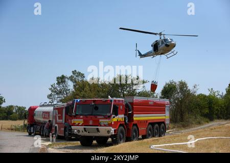 Feuerwehrleute versuchen mit einem Hubschrauber, ein Waldfeuer im Dorf Temnica in Slowenien, 22. Juli 2022 zu löschen. Rund 1.000 Feuerwehrleute haben im Westen Sloweniens einen großen Waldbrand bekämpft. Das Feuer, das durch den Wind aus Ostitalien geblasen wurde, führte zur Evakuierung mehrerer Dörfer. Foto: Sasa Miljevic/PIXSELL Stockfoto