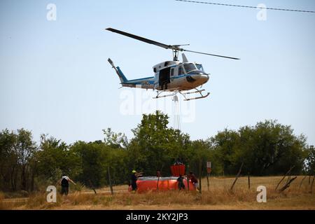 Feuerwehrleute versuchen mit einem Hubschrauber, ein Waldfeuer im Dorf Temnica in Slowenien, 22. Juli 2022 zu löschen. Rund 1.000 Feuerwehrleute haben im Westen Sloweniens einen großen Waldbrand bekämpft. Das Feuer, das durch den Wind aus Ostitalien geblasen wurde, führte zur Evakuierung mehrerer Dörfer. Foto: Sasa Miljevic/PIXSELL Stockfoto