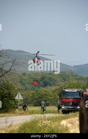 Feuerwehrleute versuchen mit einem Hubschrauber, ein Waldfeuer im Dorf Temnica in Slowenien, 22. Juli 2022 zu löschen. Rund 1.000 Feuerwehrleute haben im Westen Sloweniens einen großen Waldbrand bekämpft. Das Feuer, das durch den Wind aus Ostitalien geblasen wurde, führte zur Evakuierung mehrerer Dörfer. Foto: Sasa Miljevic/PIXSELL Stockfoto