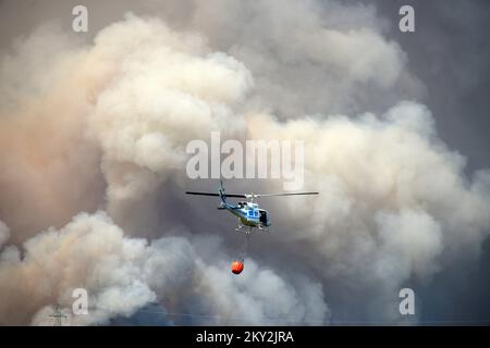 Feuerwehrleute versuchen mit einem Hubschrauber, ein Waldfeuer im Dorf Temnica in Slowenien, 22. Juli 2022 zu löschen. Rund 1.000 Feuerwehrleute haben im Westen Sloweniens einen großen Waldbrand bekämpft. Das Feuer, das durch den Wind aus Ostitalien geblasen wurde, führte zur Evakuierung mehrerer Dörfer. Foto: Sasa Miljevic/PIXSELL Stockfoto